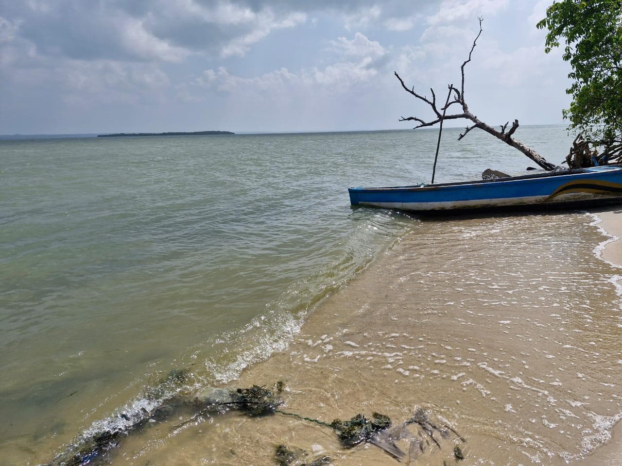 Blue fishing boat resting on the sandy shore