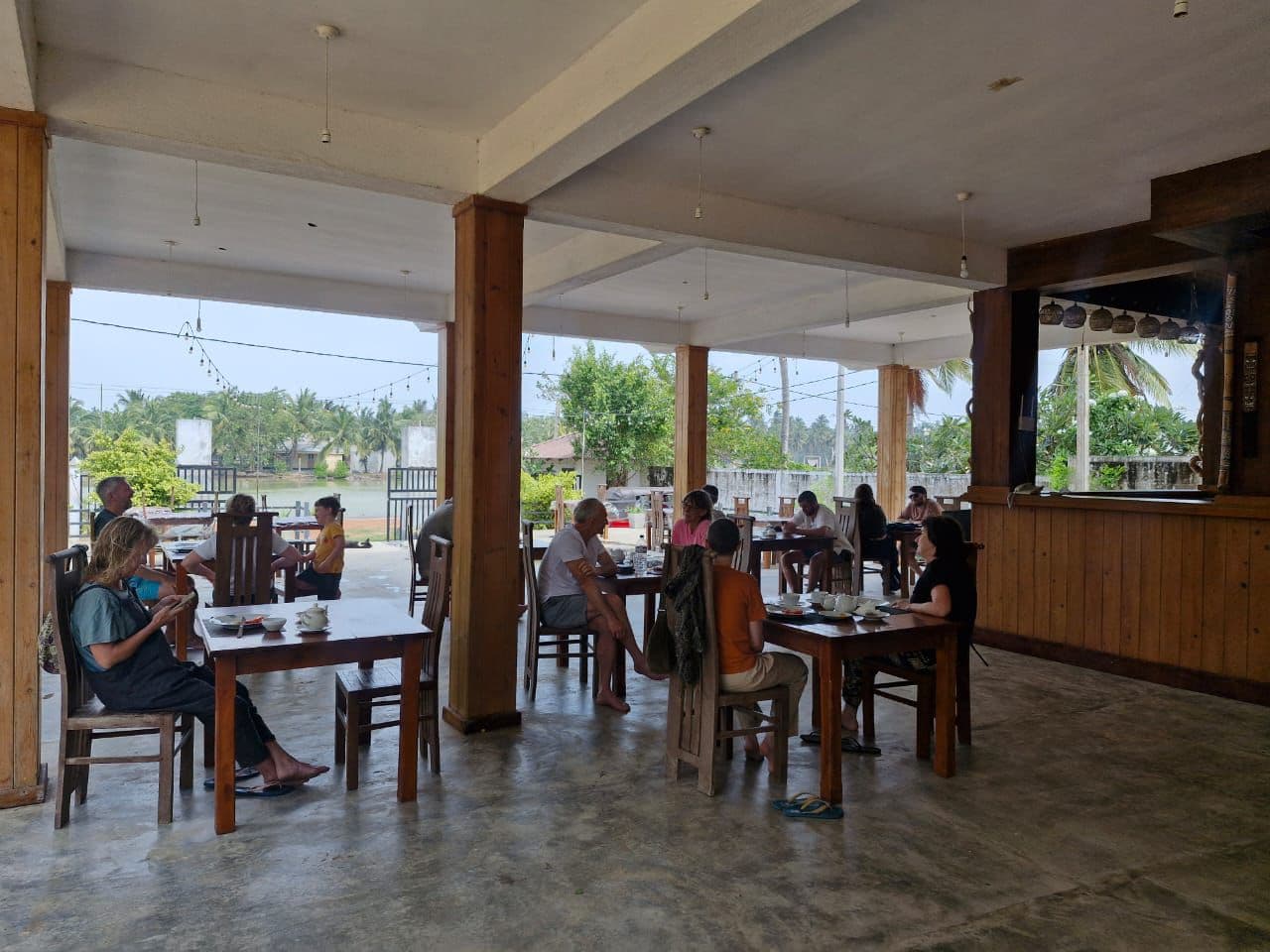 Guests dining in an open-air restaurant with lagoon view