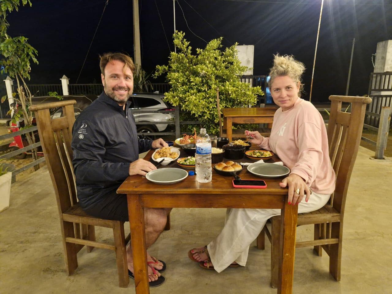Couple enjoying seafood dinner outdoors at night